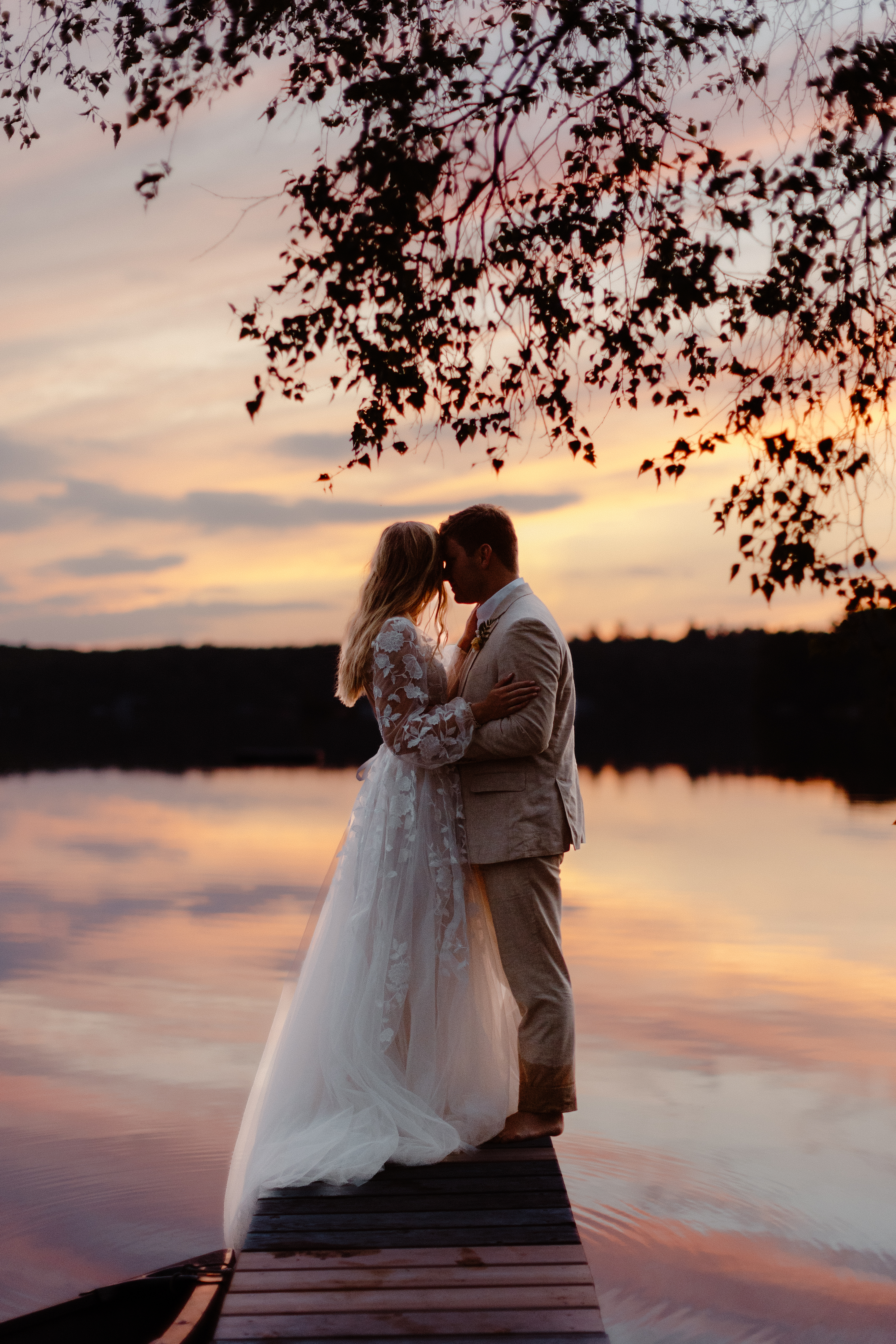bride and groom on dock at sunset