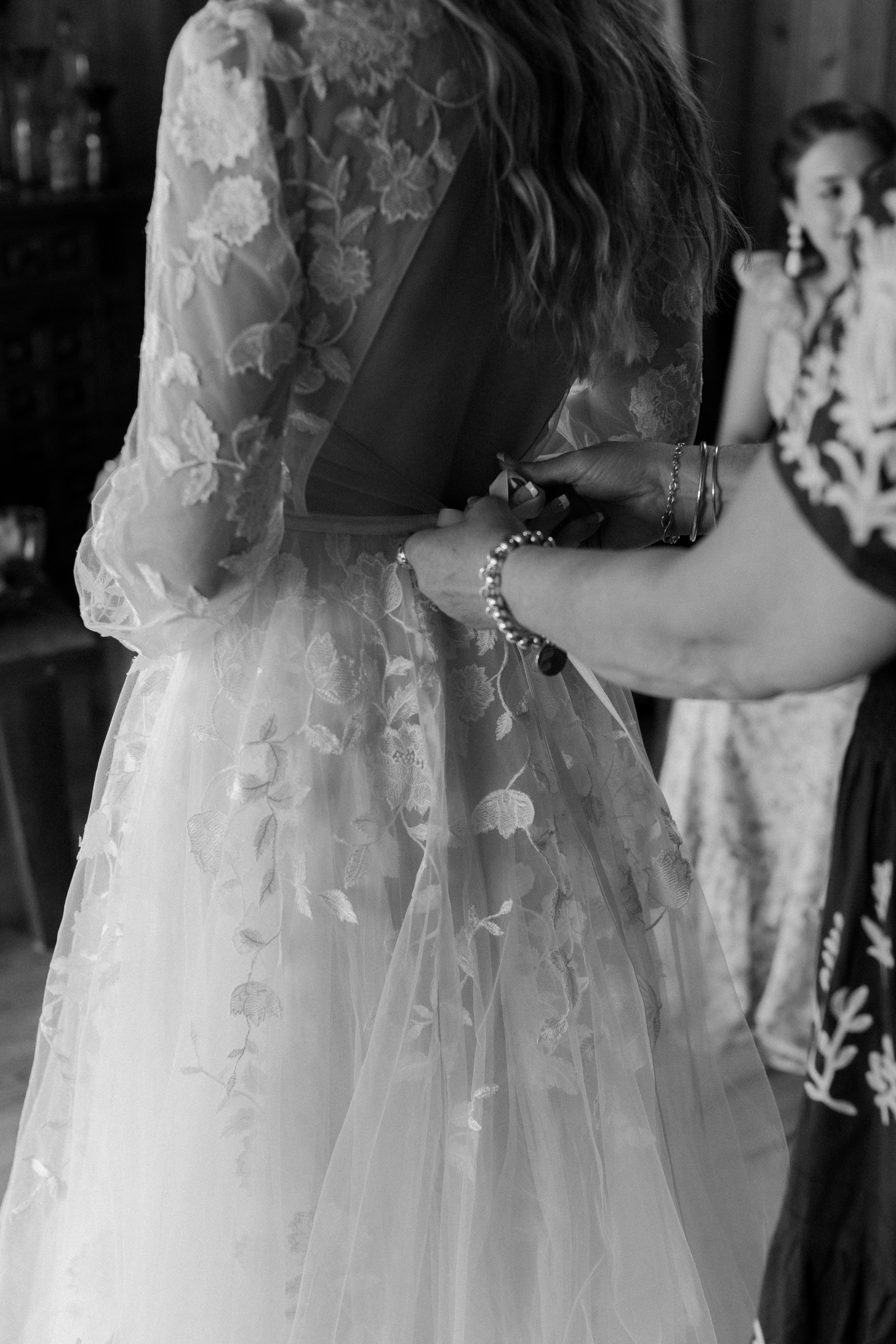 bride's mom fastening bride's dress