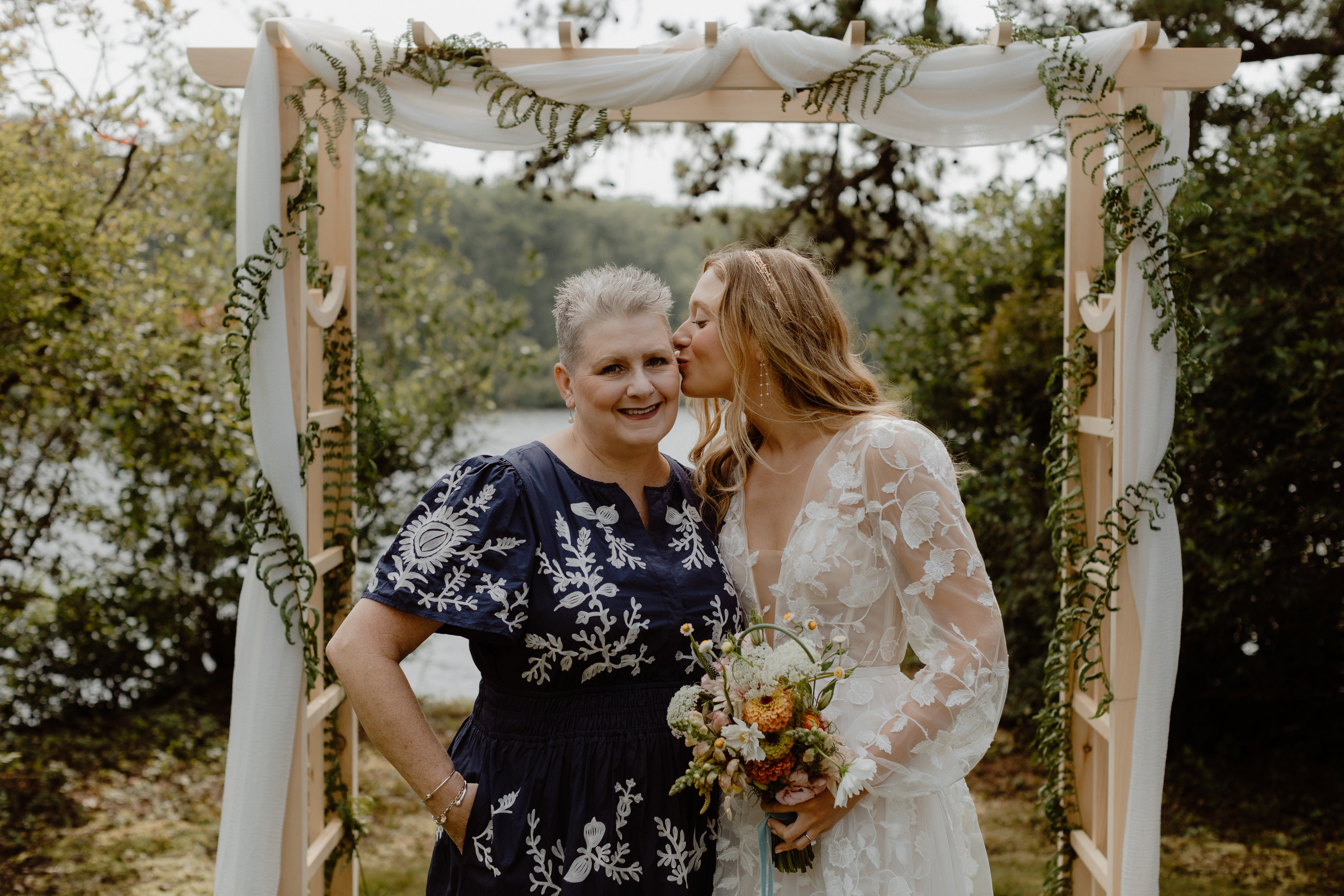 bride kissing mom on cheek