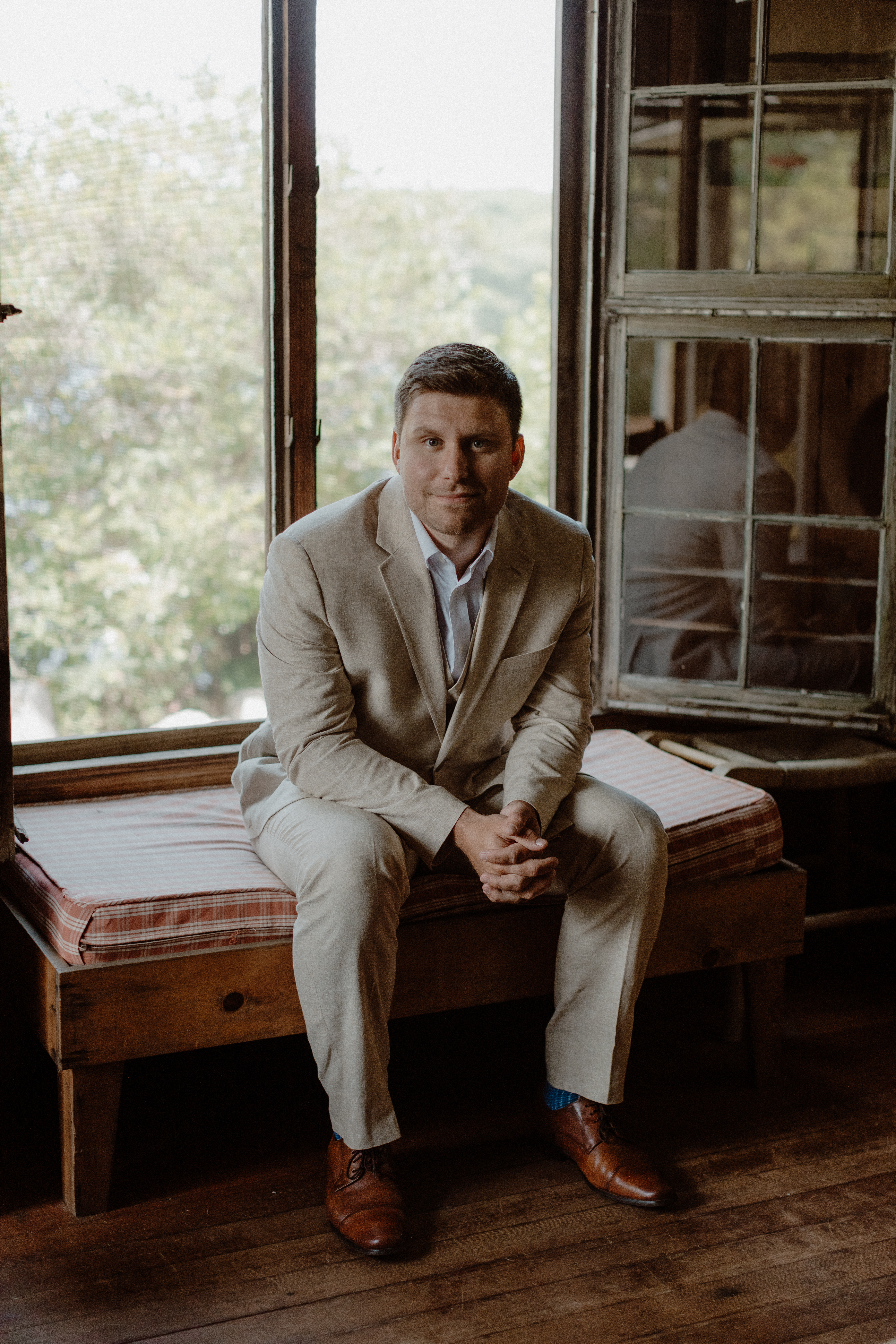 groom sitting on window seat