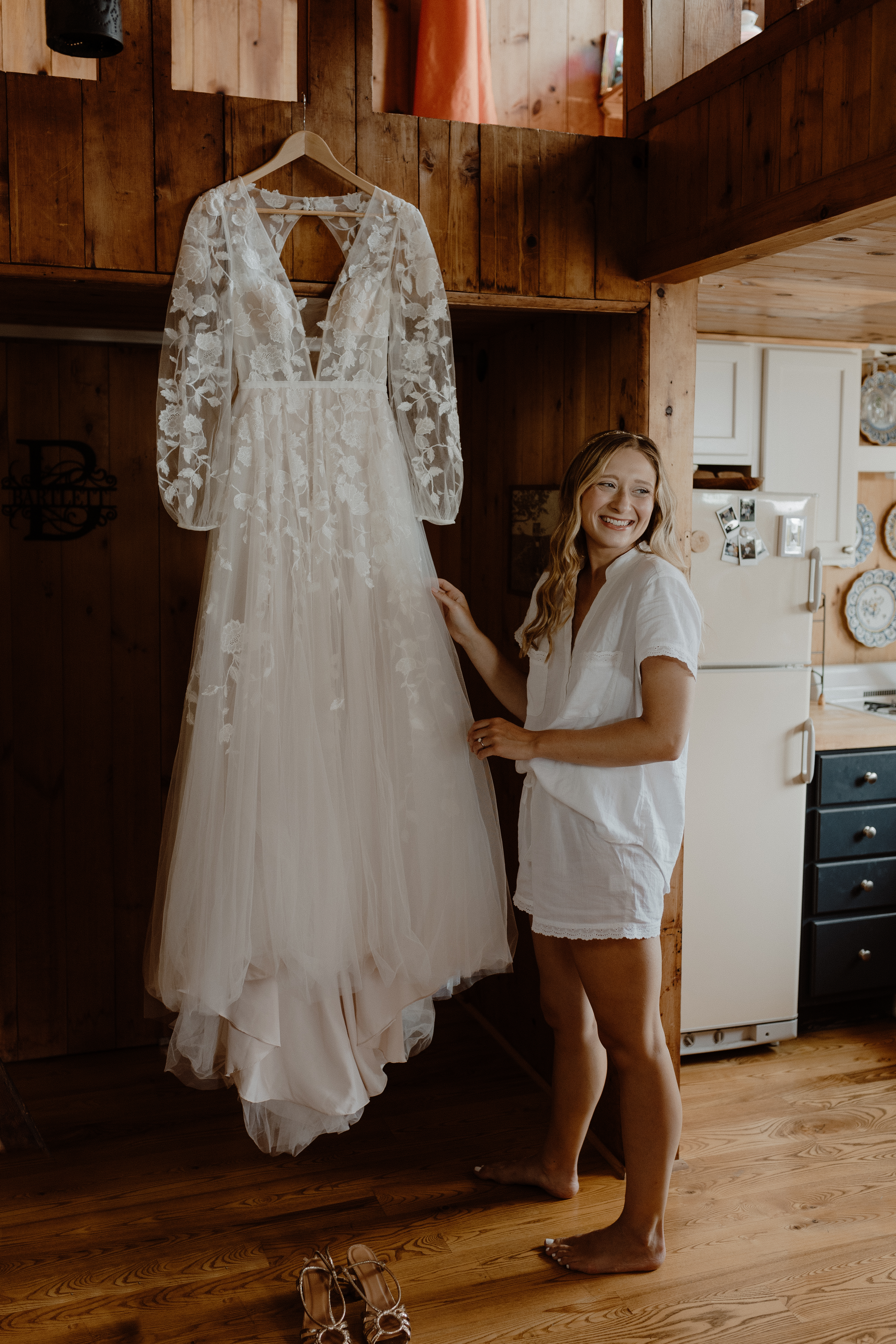 bride smiling next to her hanging dress