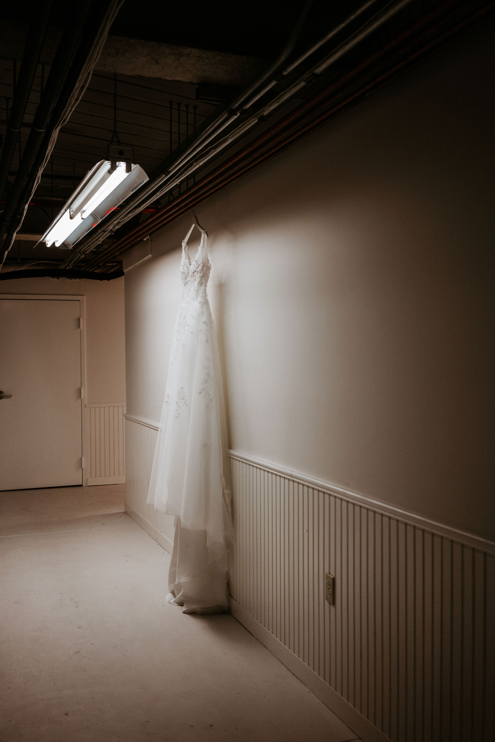 wedding dress hanging up in hallway