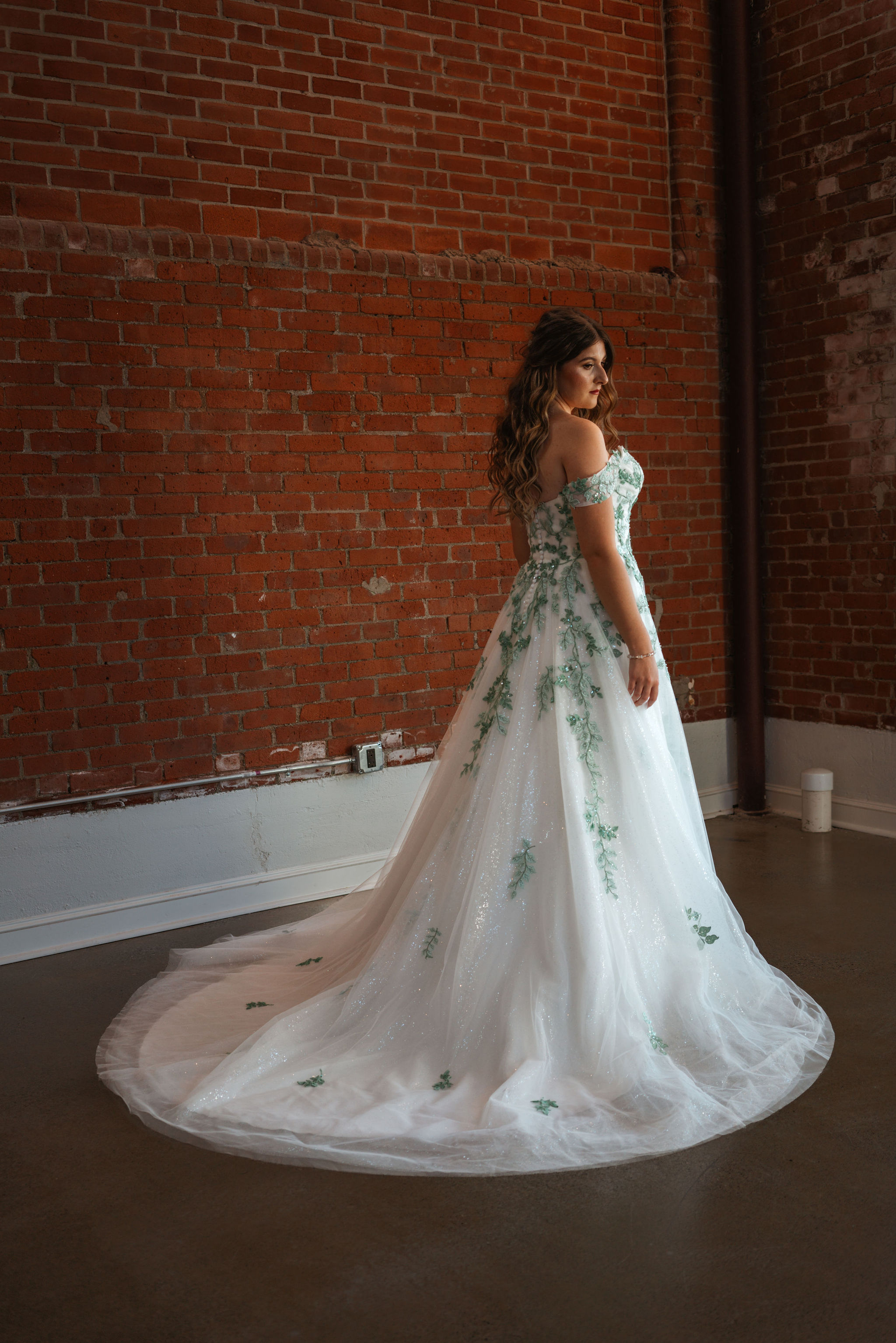 bride posing with greenery wedding dress details