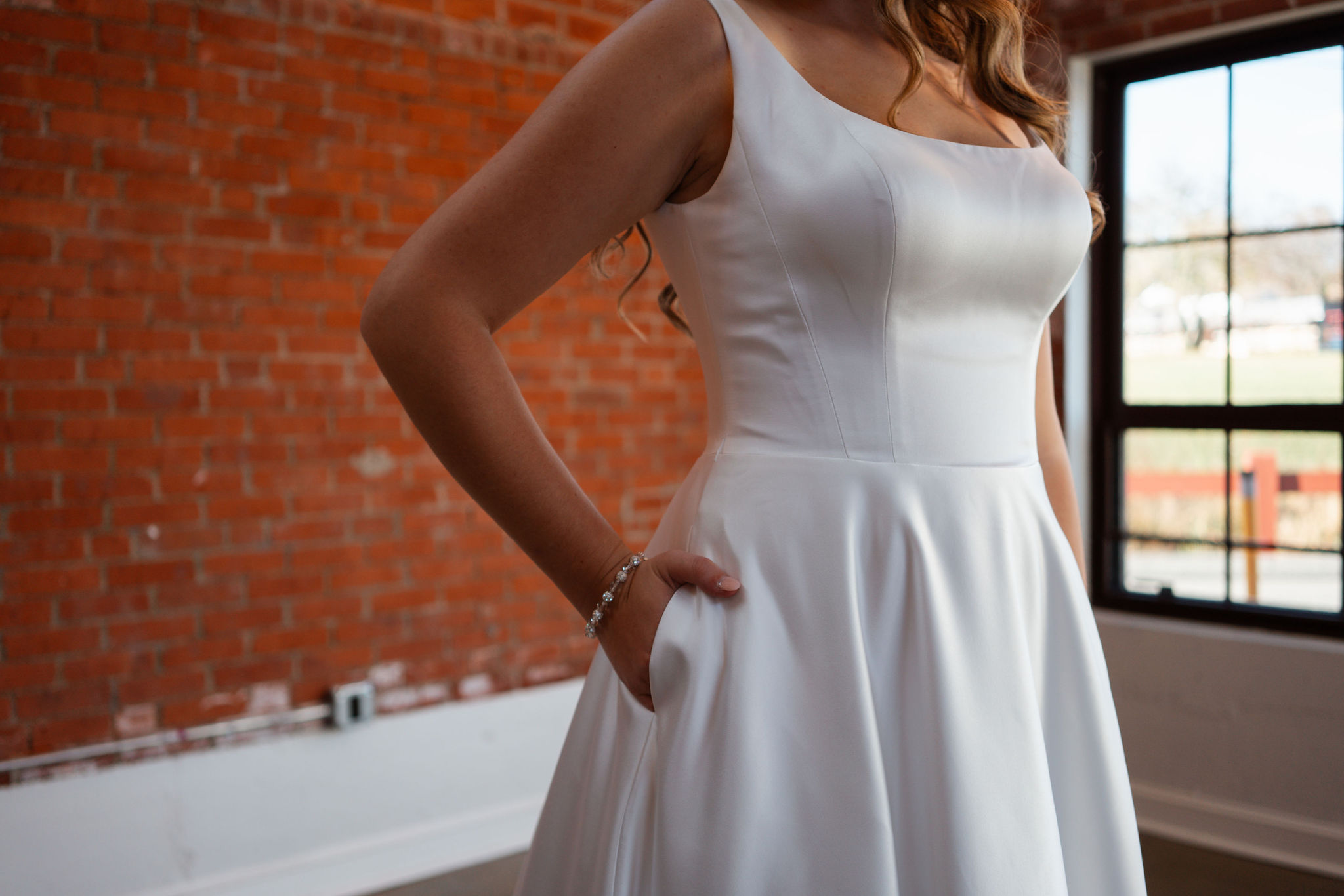detail shot of simple wedding dress and bride's jewelry