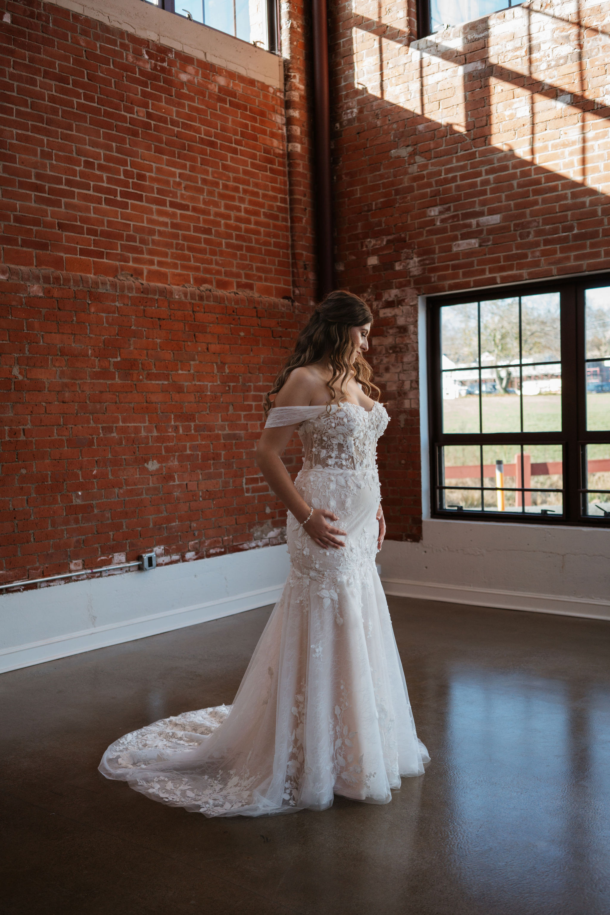bride posing in her wedding dress in brick venue
