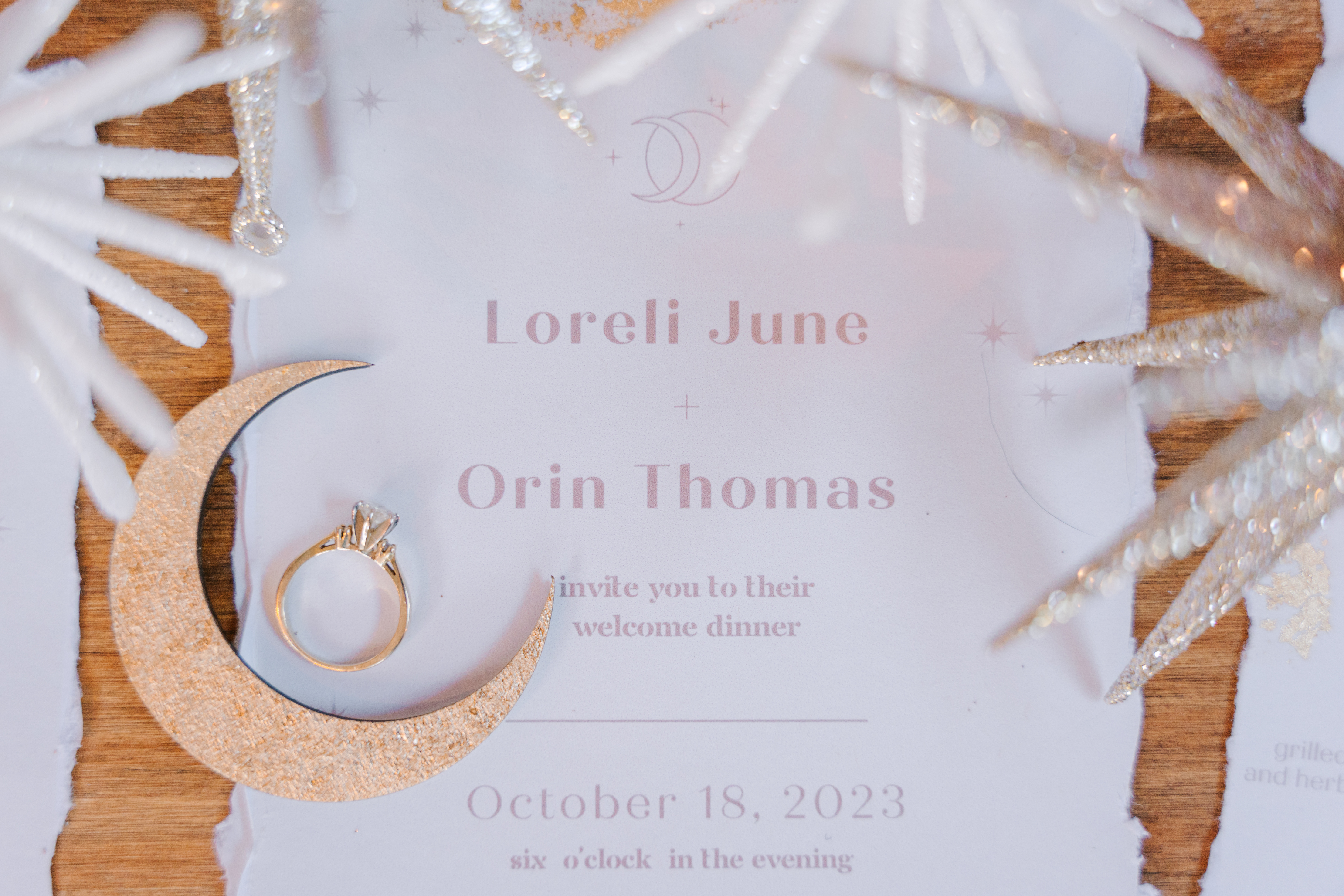 detail shot of wedding invitation with engagement ring